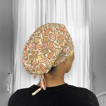 A person wearing a scrub cap with a colorful ghost and floral pattern. The cap features shades of orange, yellow, and bronze, with the birds designed in checkered style.