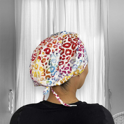 A person wearing a colorful rainbow cheetah print scrub cap.