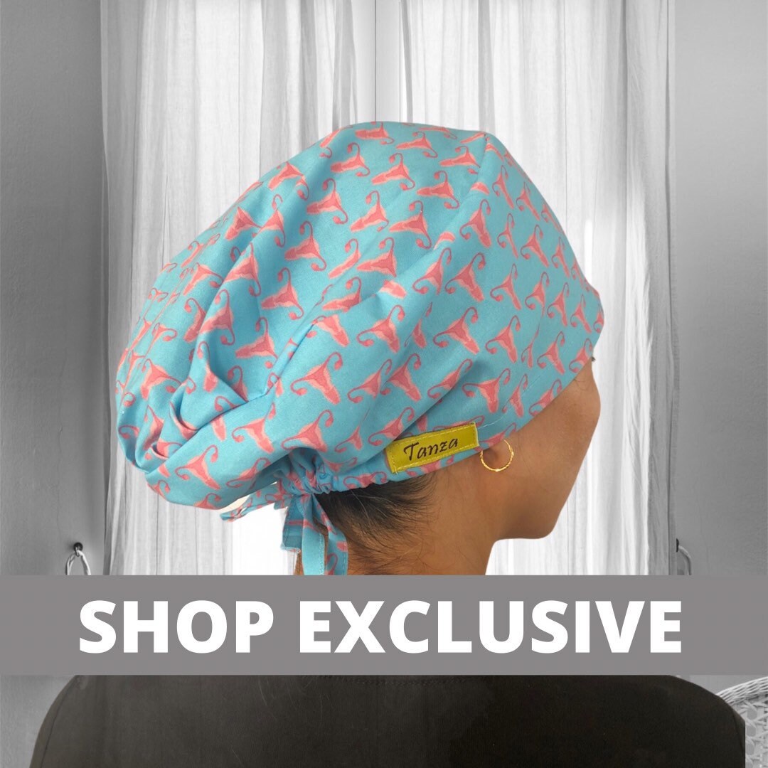 A person wearing a stylish scrub cap with a uterus surrounding on a light blue background.